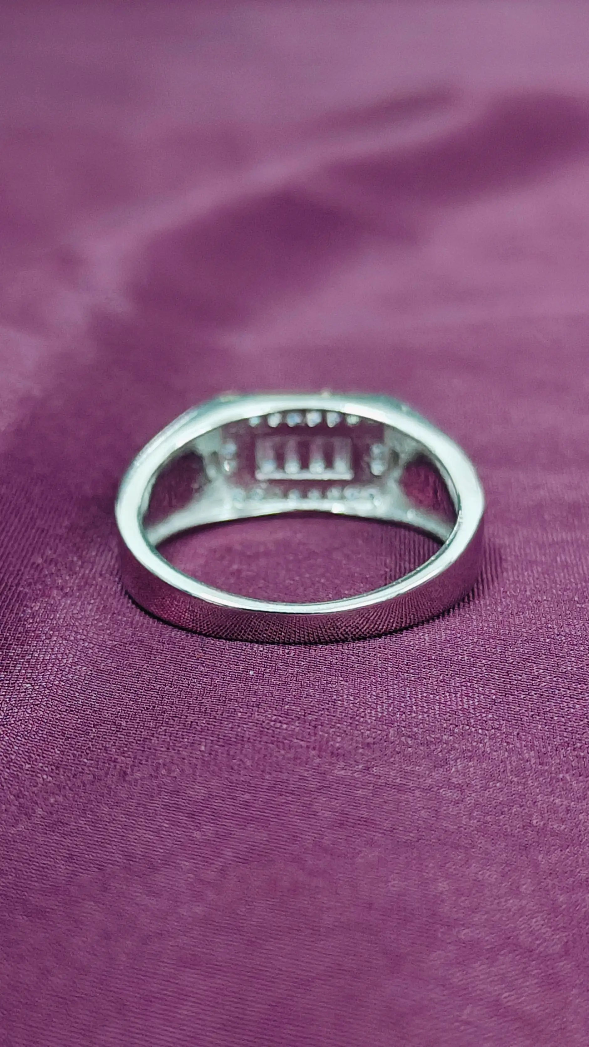 Silver ring on a purple fabric background